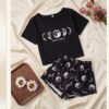 e3f53725-ec6c-4f02-aba7-543c4d43fca1 “Moon Child” Pyjama Set — Black Moon Phase Print Tee & Shorts